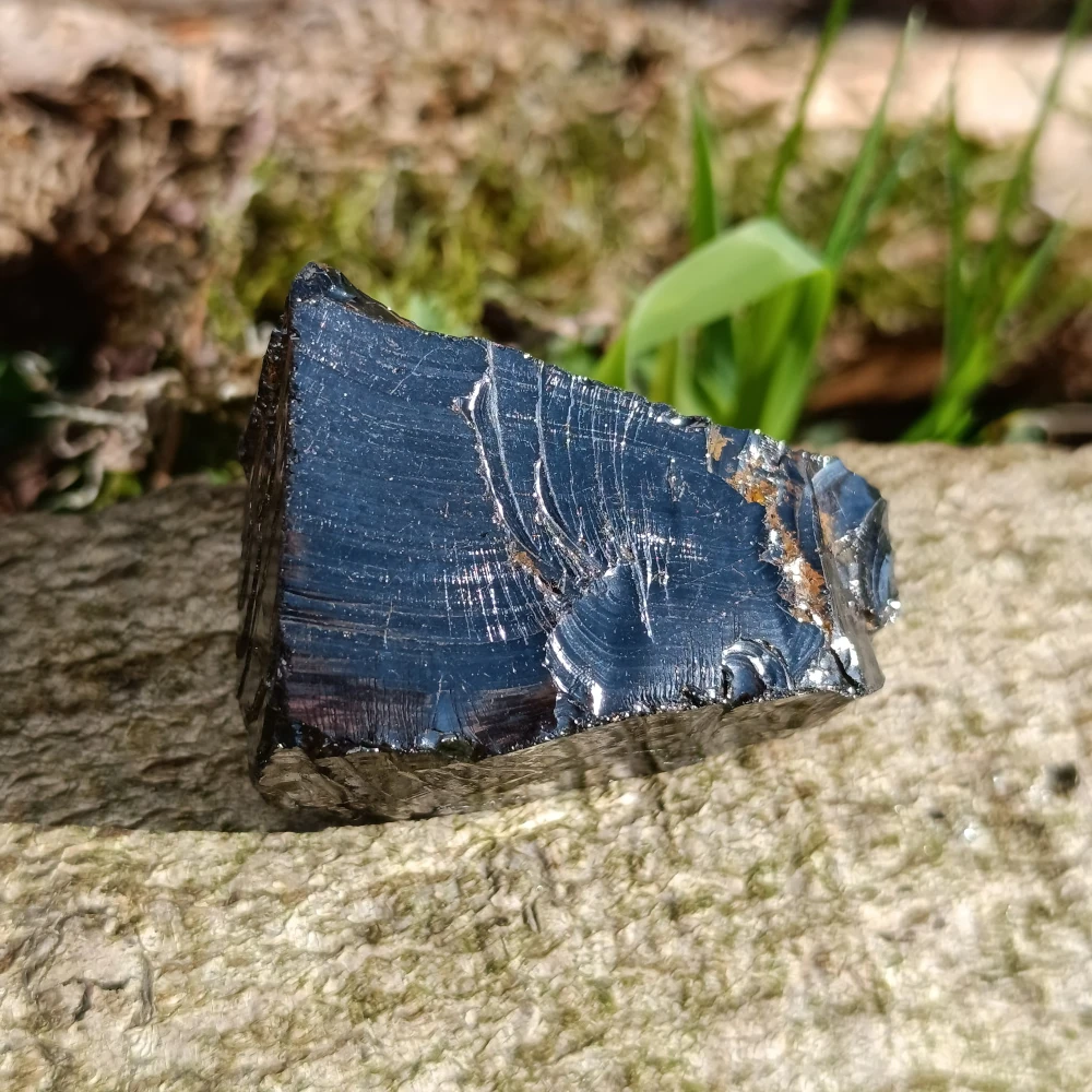 Silbrig glaenzender Edel-Schungit auf Holz.