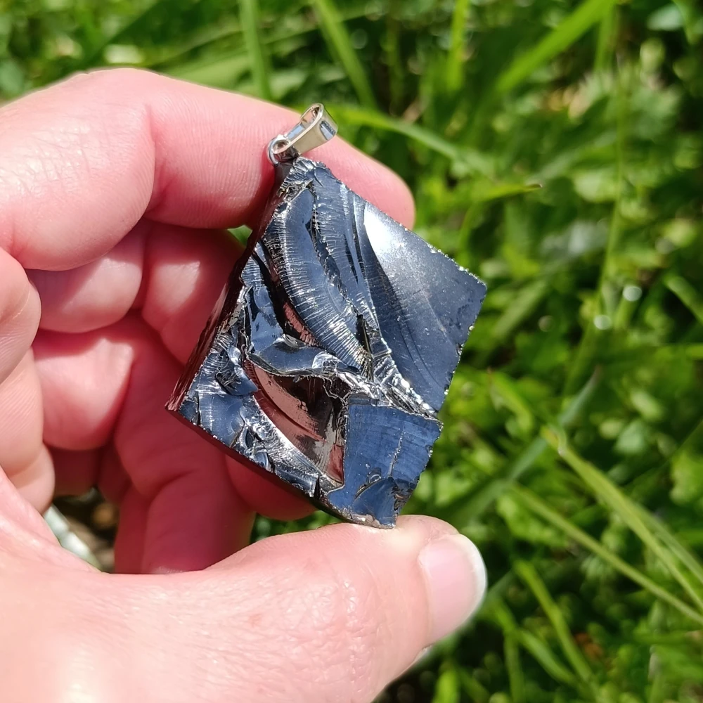 Im Sonnenlicht funkelnder Anhaenger aus Edelschungit.