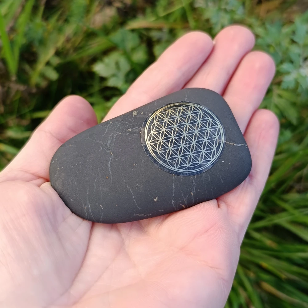 Schungit getrommelter Stein mit Symbol der Lebensblume