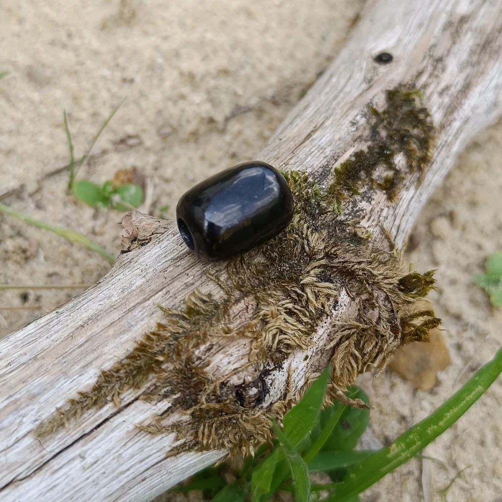 Toennchen aus Schungit auf Holz liegend