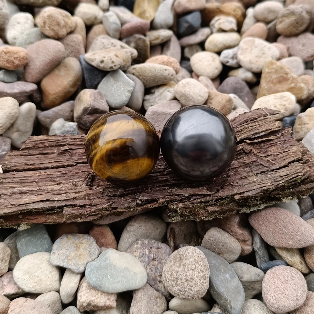 Tigerauge und Schungit kugeln auf Splittern
