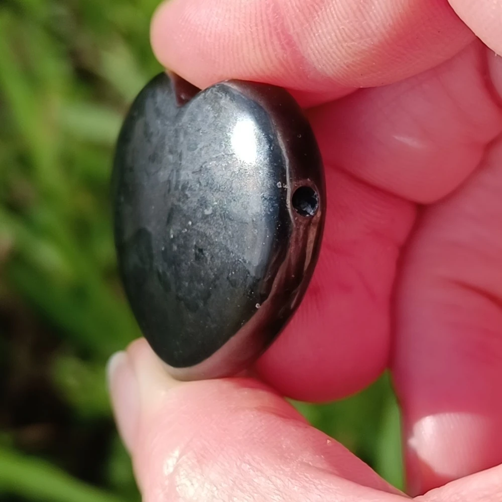 Seitliche Ansicht eines Herzform Steines aus Schungit