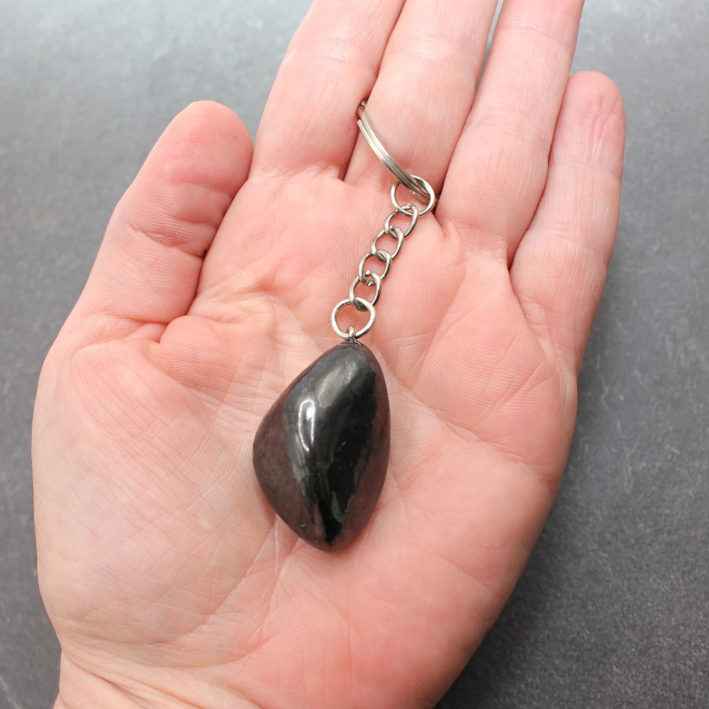 Trommelstein Schluesselanhaenger Freeform aus Schungit in der Hand