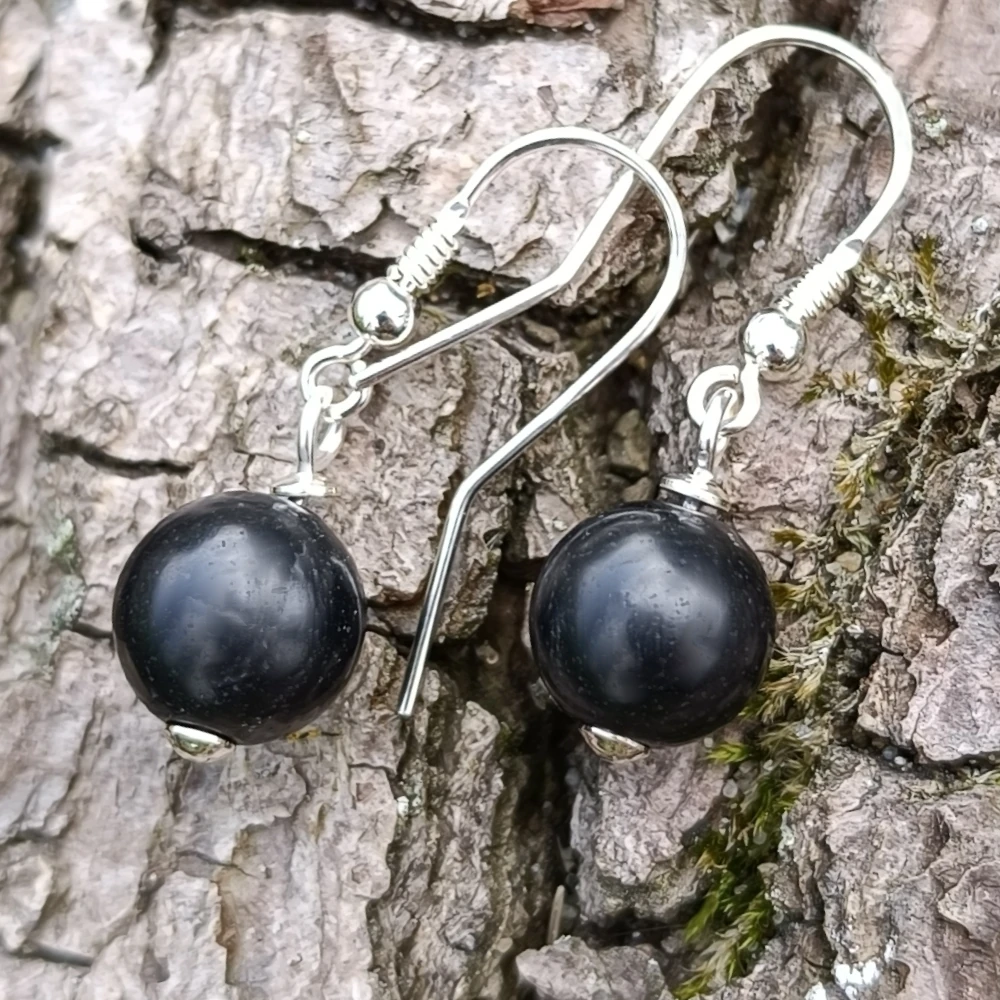 Ohrringe Perle aus Schungit auf Holz liegend