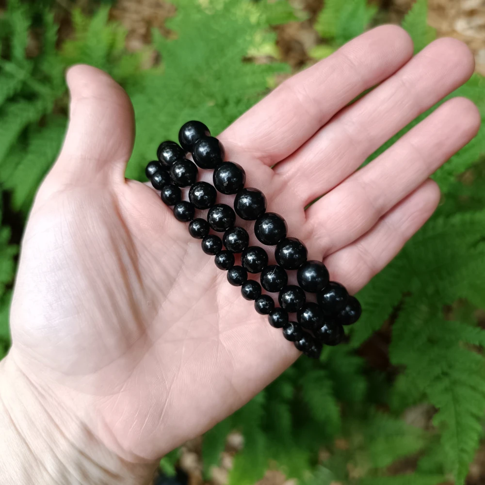 Drei Groessen Schungit Armbaender in der Hand