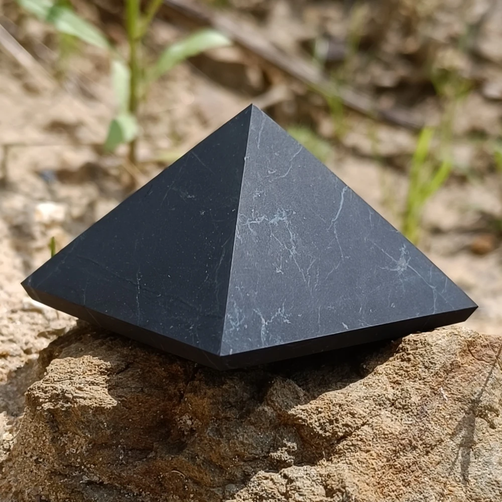 Pyramide aus Schungit auf einem Stein