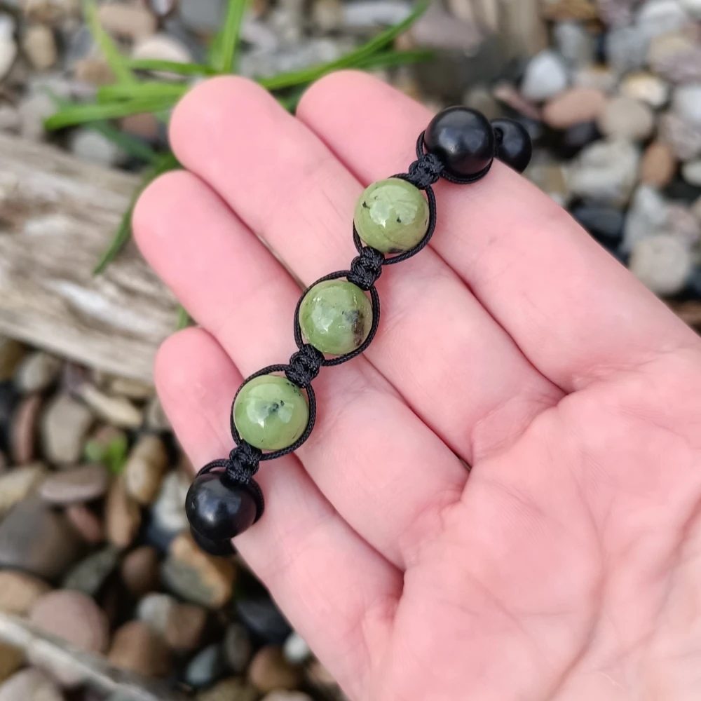 Armband aus Schungit und gruener Jade in der Hand