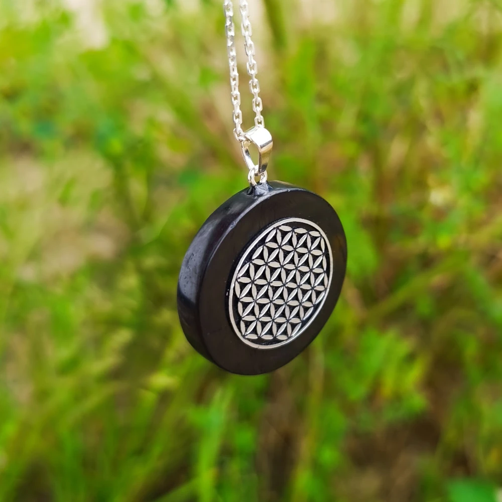 Seitlich haengender Schungit Anhaenger mit Lebensblume Symbol in Silber