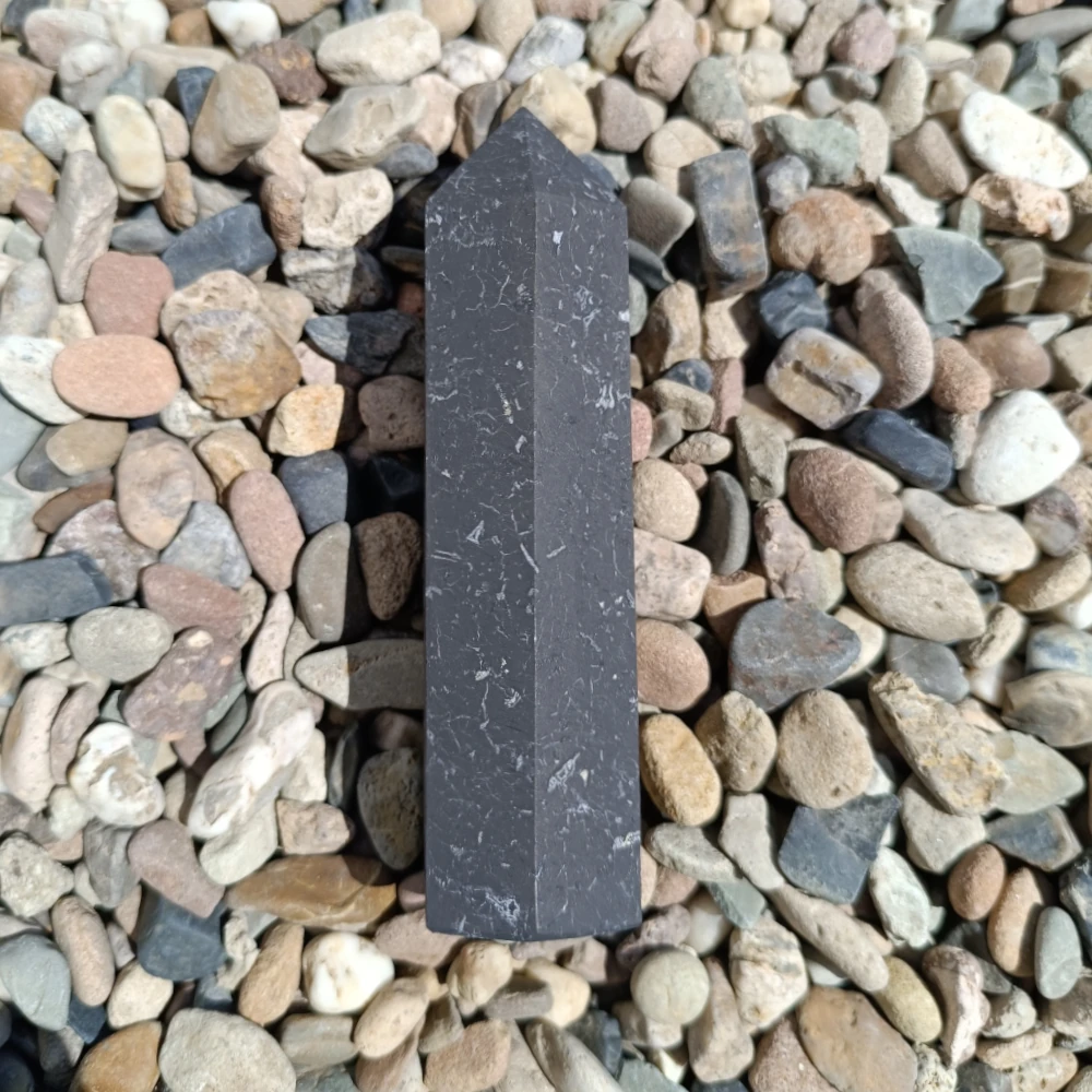 Großer Schungit-Obelisk, unpoliert, dunkelgrau, auf Kieselsteinen