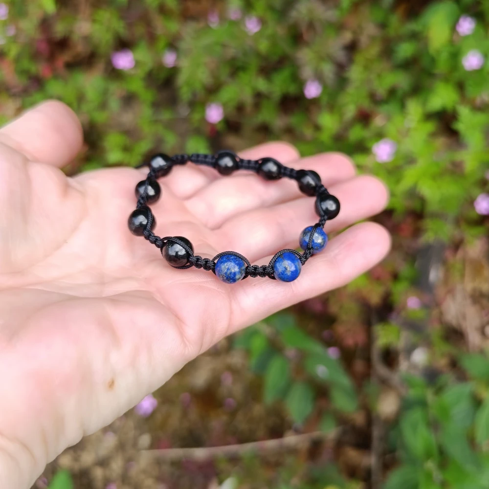 Schungit und Lapislazuli Armband in der Hand liegend
