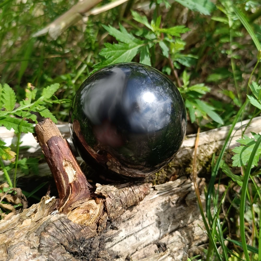 Auf Holz liegende Kugel aus Schungit