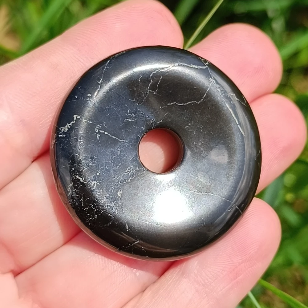 Schungit Donutanhaenger mit Pyritmaserung in der Hand
