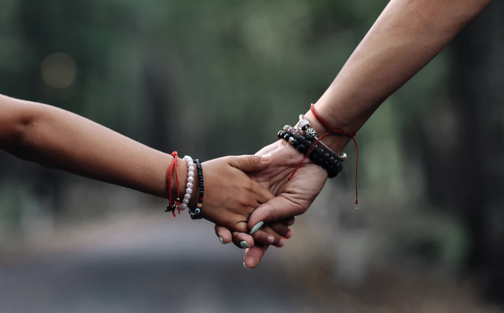 Mann und Frau halten sich an den Haenden.