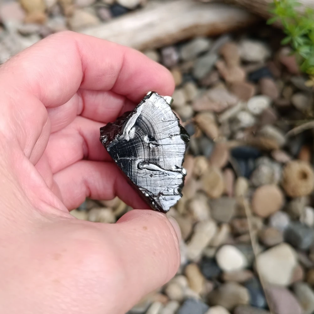 Glaenzender Freeform Edel Schungit Anhaenger in der Hand