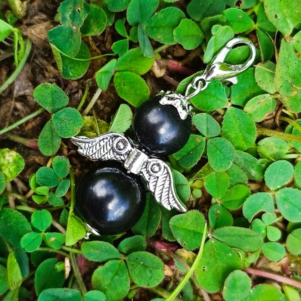 Engel aus zwei Perlen aus Schungit auf Klee liegend