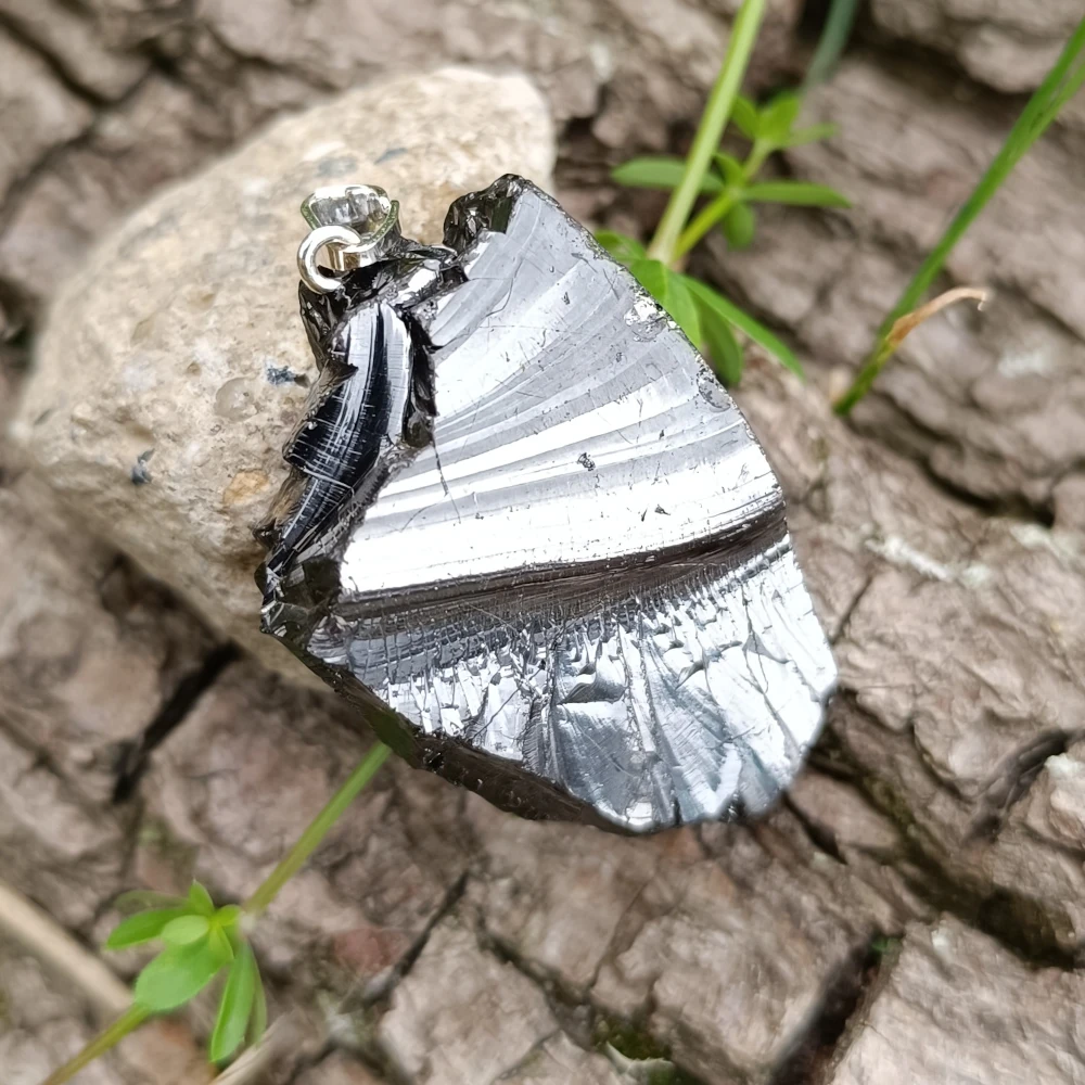 Glaenzender Kettenanhaenger aus Edelschungit mit einer glaenzenden Welle