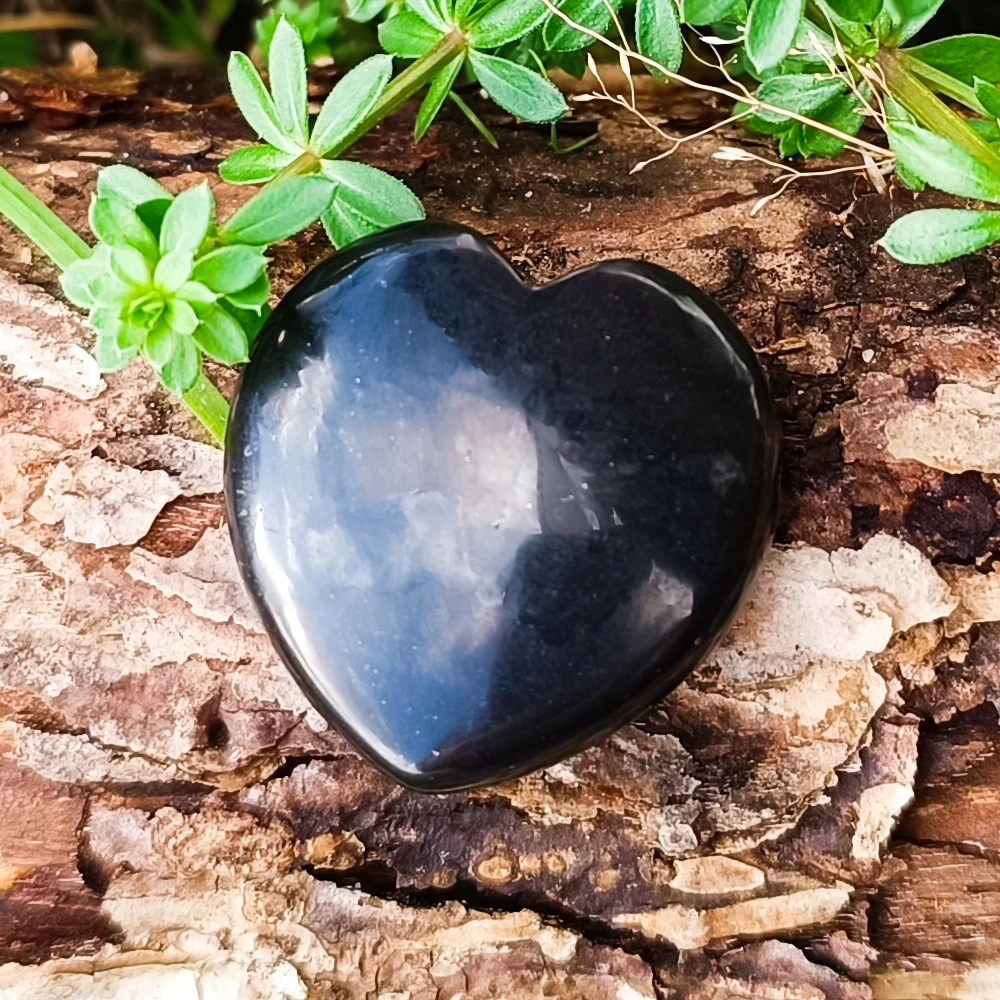 Halsanhaenger aus Schungit in Herzform liegend auf Holz