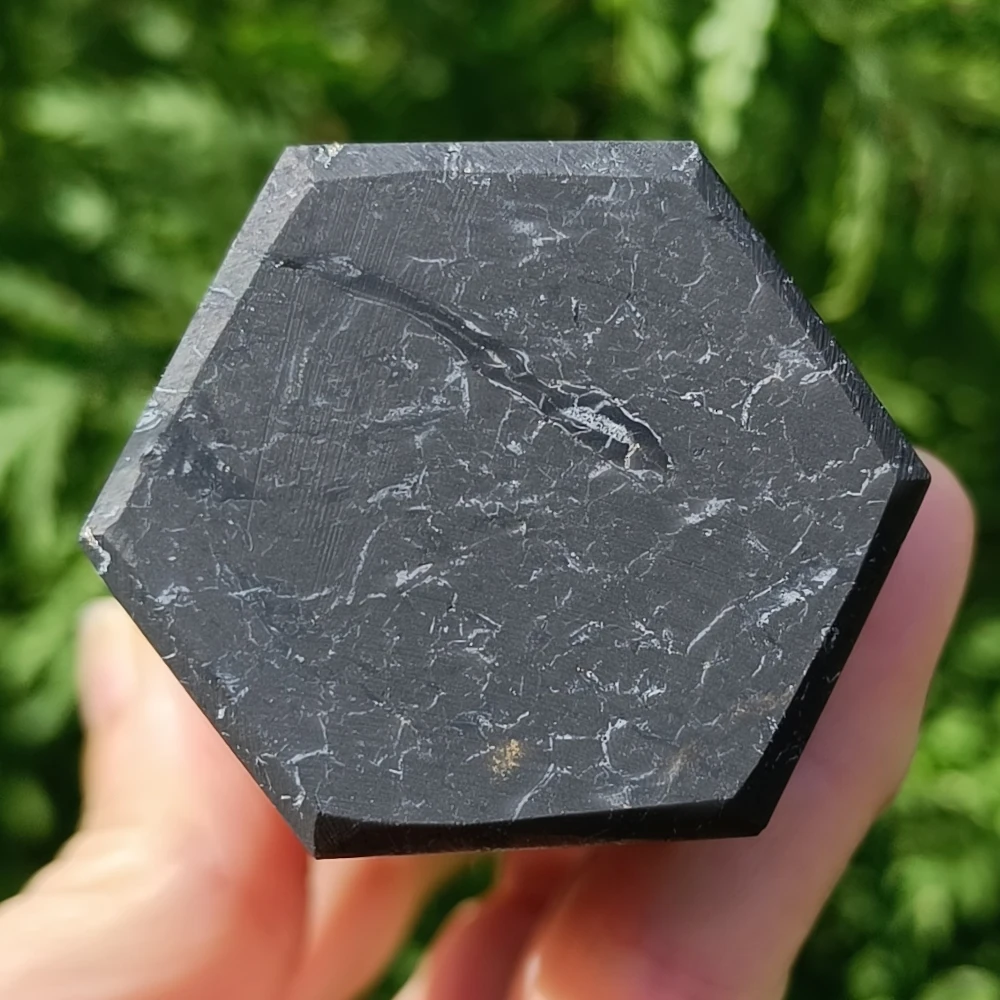 Schungit-Obelisk, sechseckige Basis, poliert, in der Hand gehalten