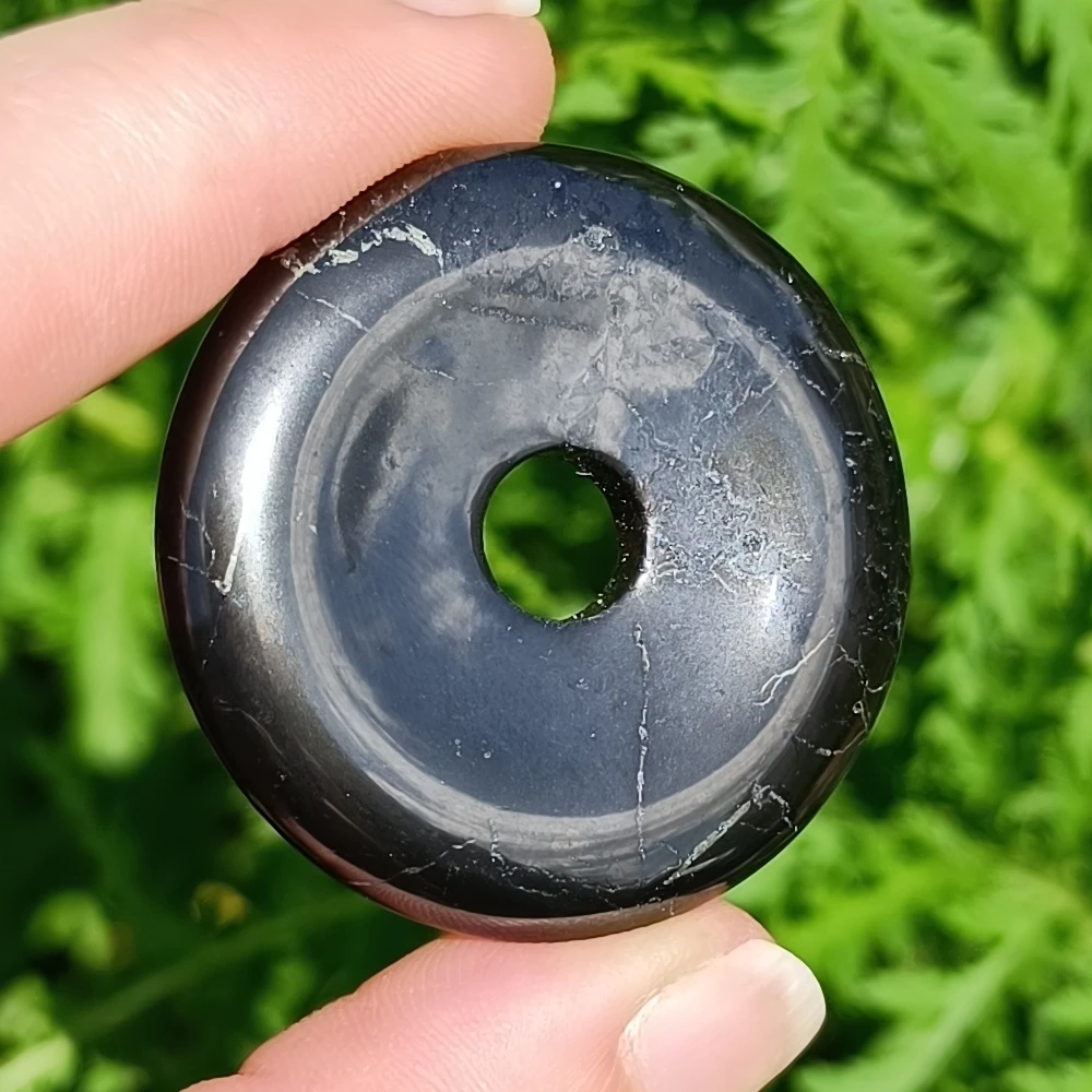 Schungit-Donut Nahaufnahme in der Sonne