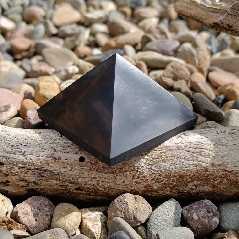 Auf Holz stehende Pyramide aus Schungit in polierter Form