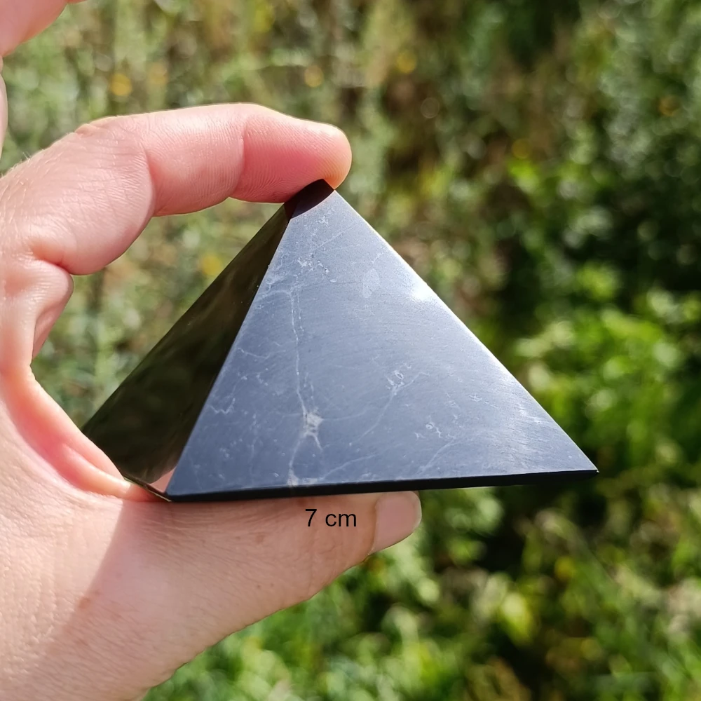 Polierte Schungit Pyramide zweischen zwei Fingern
