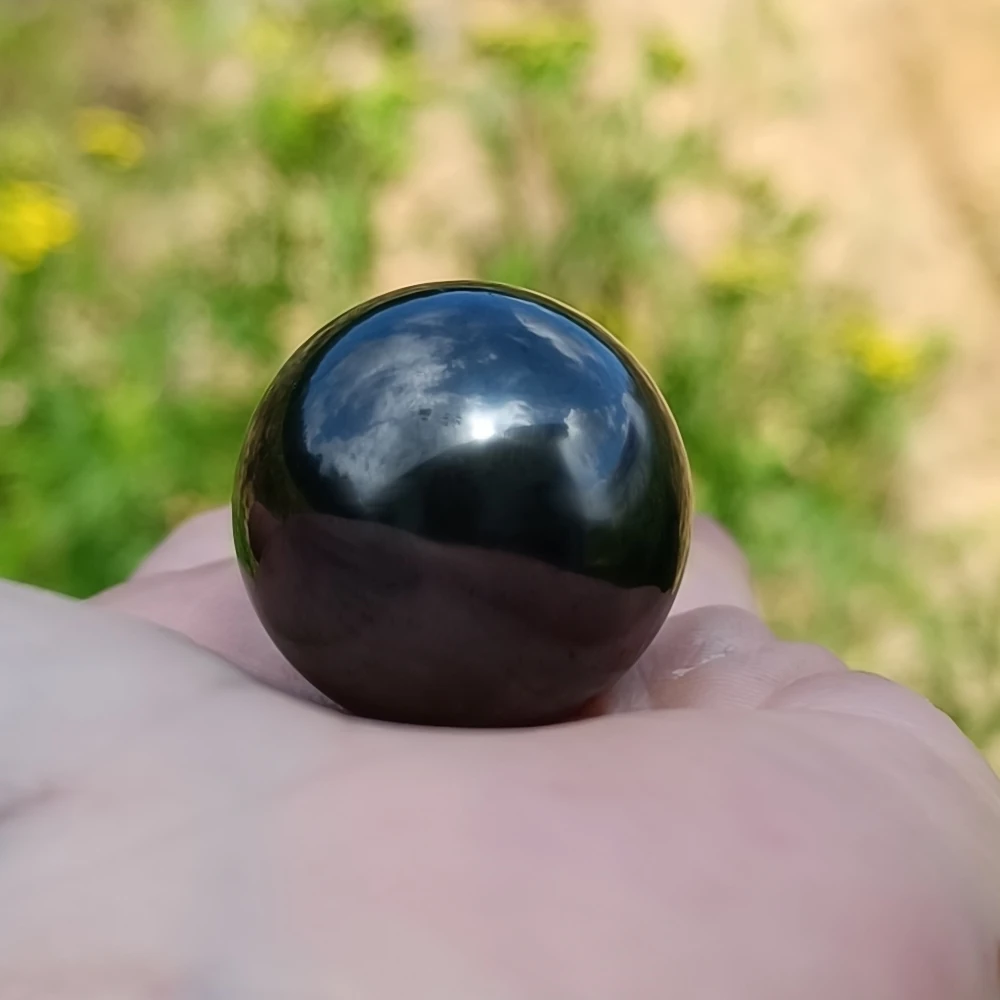 Kleine Kugel aus Schungit in der Hand
