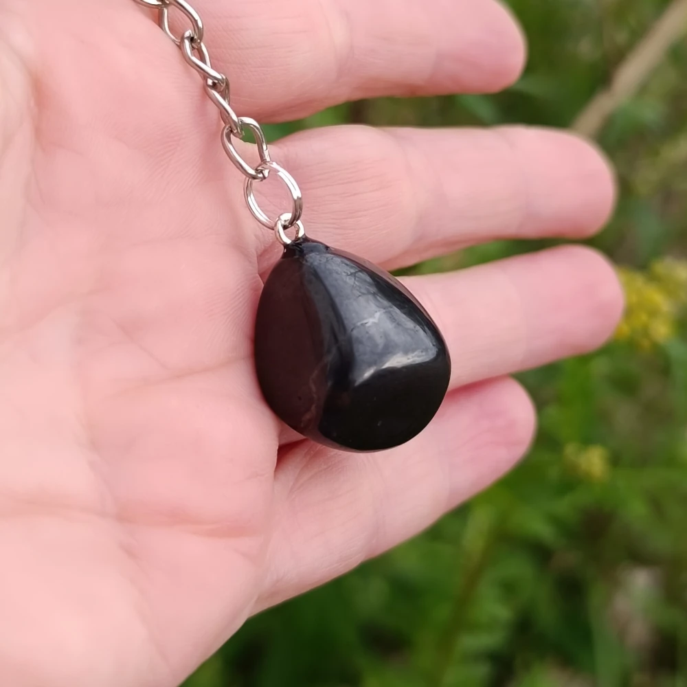 Tropfenfoermiger Schungit Nugget Schluesselanhaenger in der Hand