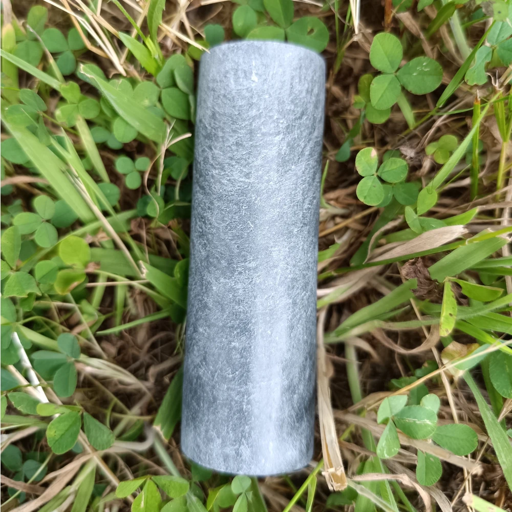Talkchlorit-Zylinderstab poliert, hellgrau, auf Naturuntergrund liegend