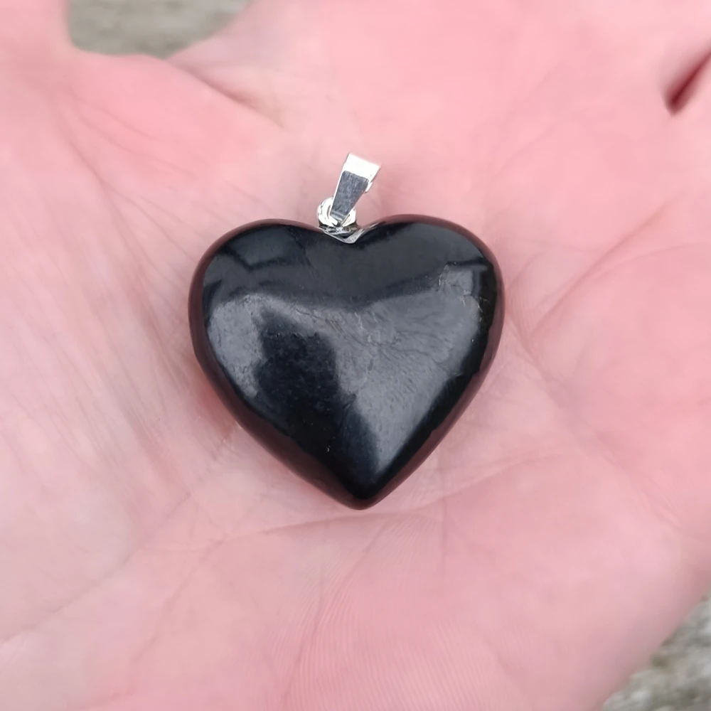 Herzform Anhaenger aus Schungit in der Hand