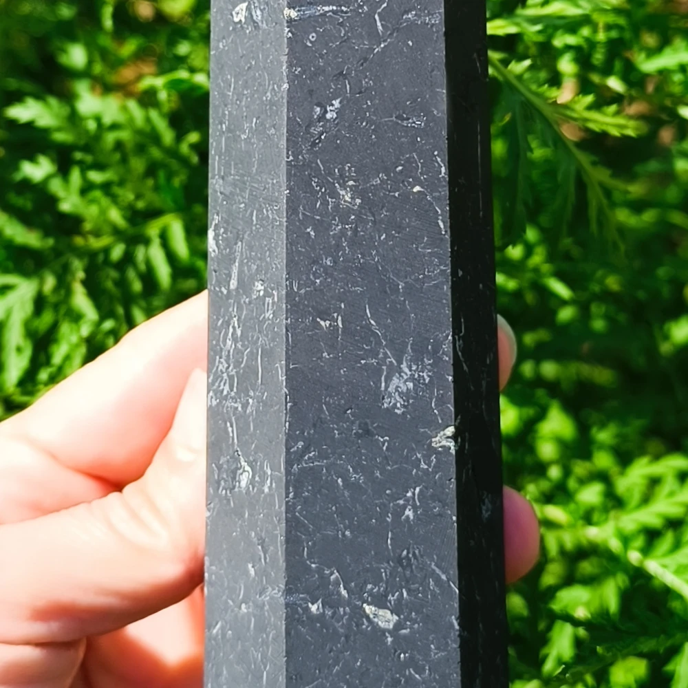 Schungit-Obelisk, poliert, Nahaufnahme, in der Hand gehalten