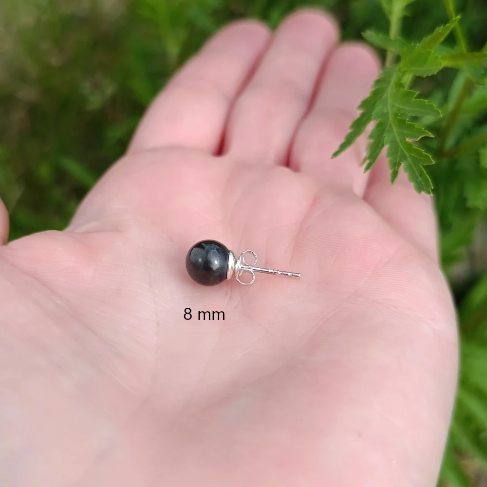 Acht Millimeter Kleiner Ohrstecker aus Schungit in der Hand