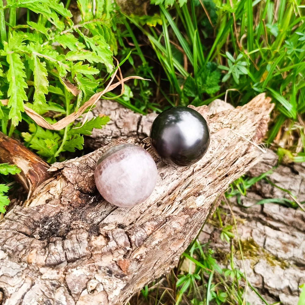 Auf Holz liegende Schungit und Fluorit Kugeln