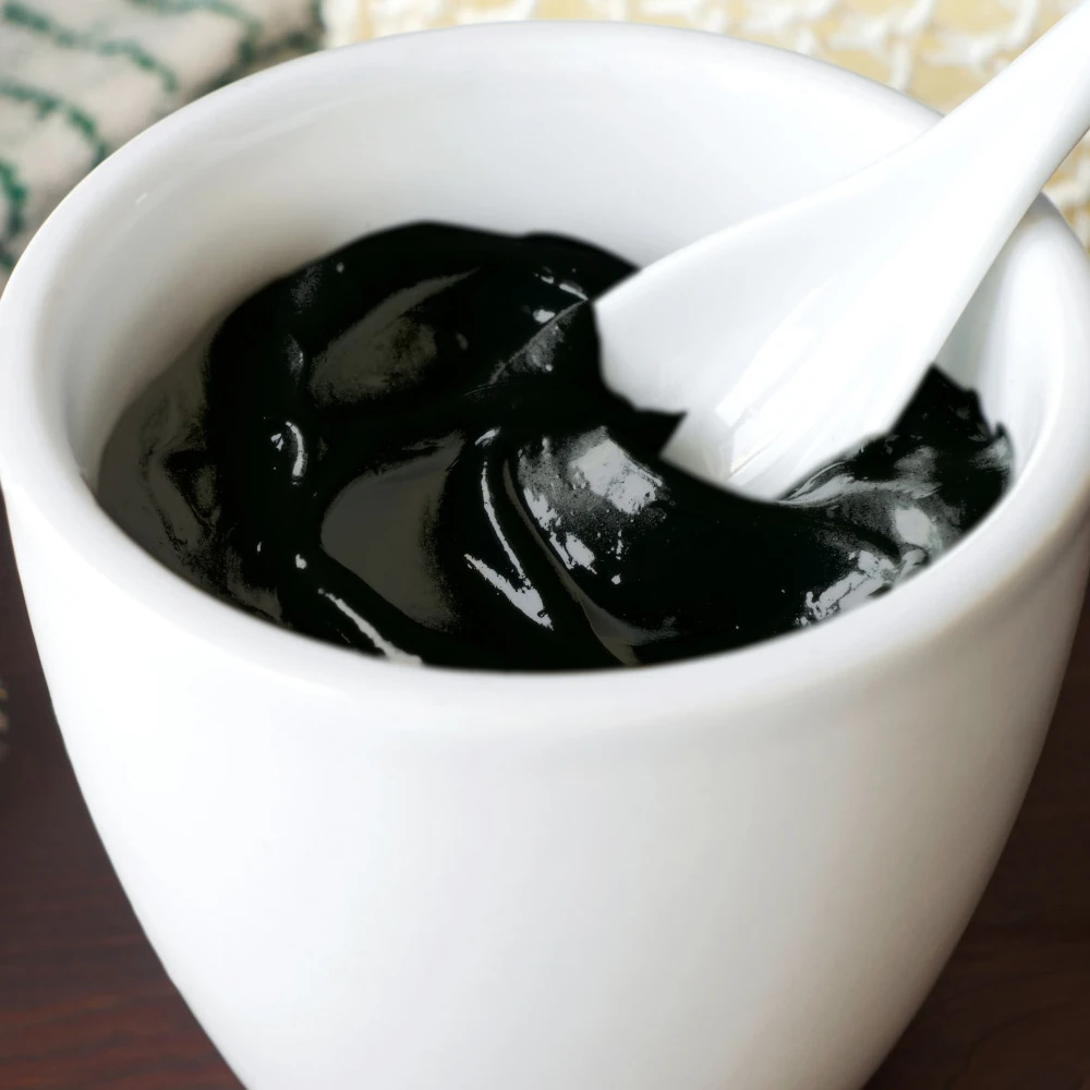 Paste aus Schungitpulver angerührt in einem Gefaess