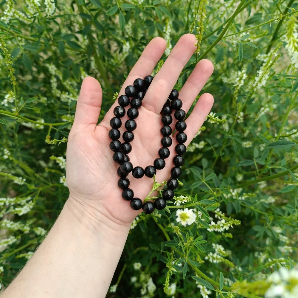In der Hand liegende Kette aus Schungit Kugeln