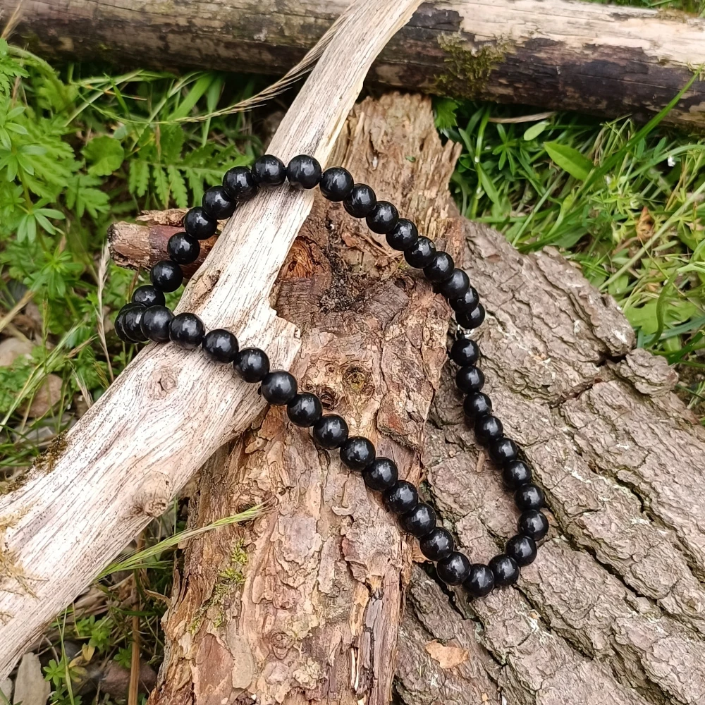 Kugelhalskette aus Schungit auf Holz liegend