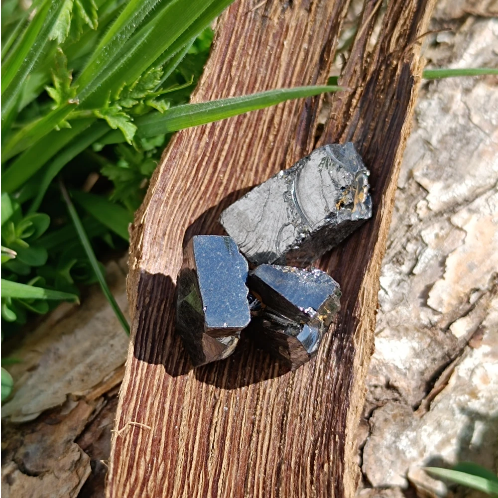 Drei kleine Edelschungite als Wassersplitt.