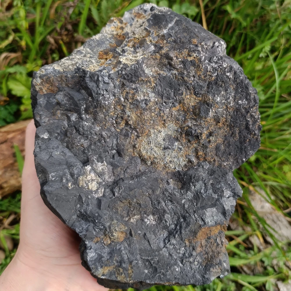 In der Hand haltender Rohstein aus Schungit