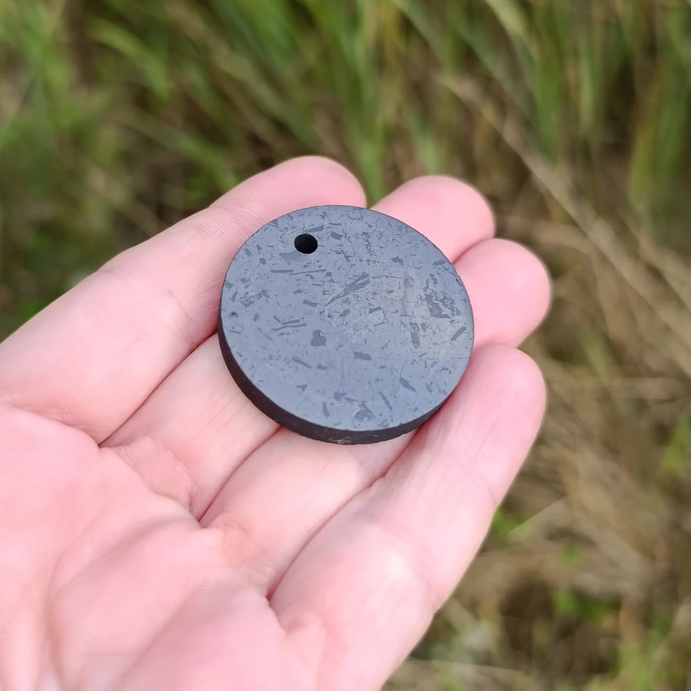 Schungit Scheiben Anhaenger in der Hand