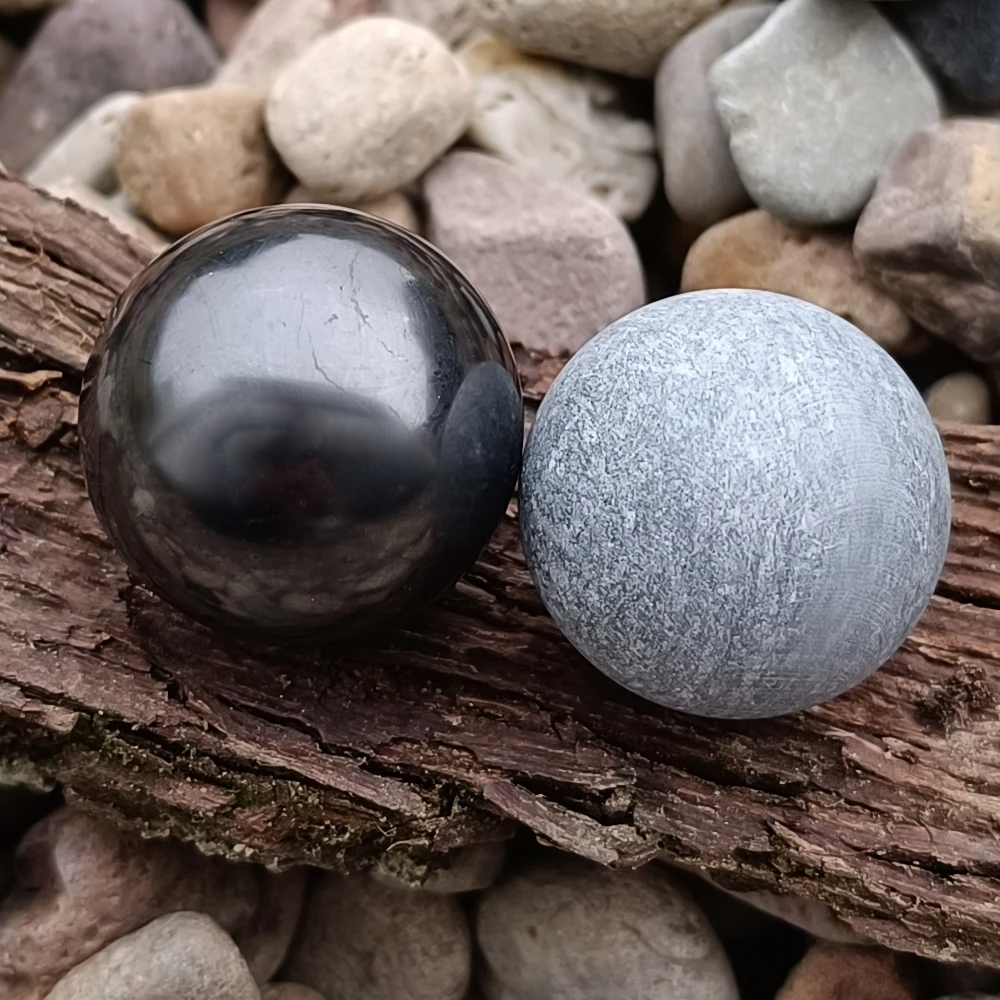 Schungit- und Talkchloritkugeln auf Holz
