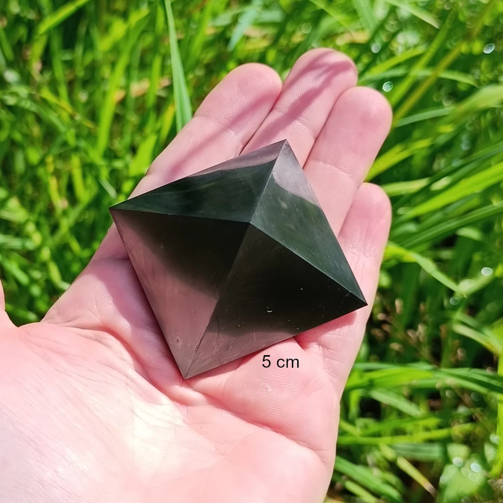 In der Hand liegende polierte Schungit Pyramide