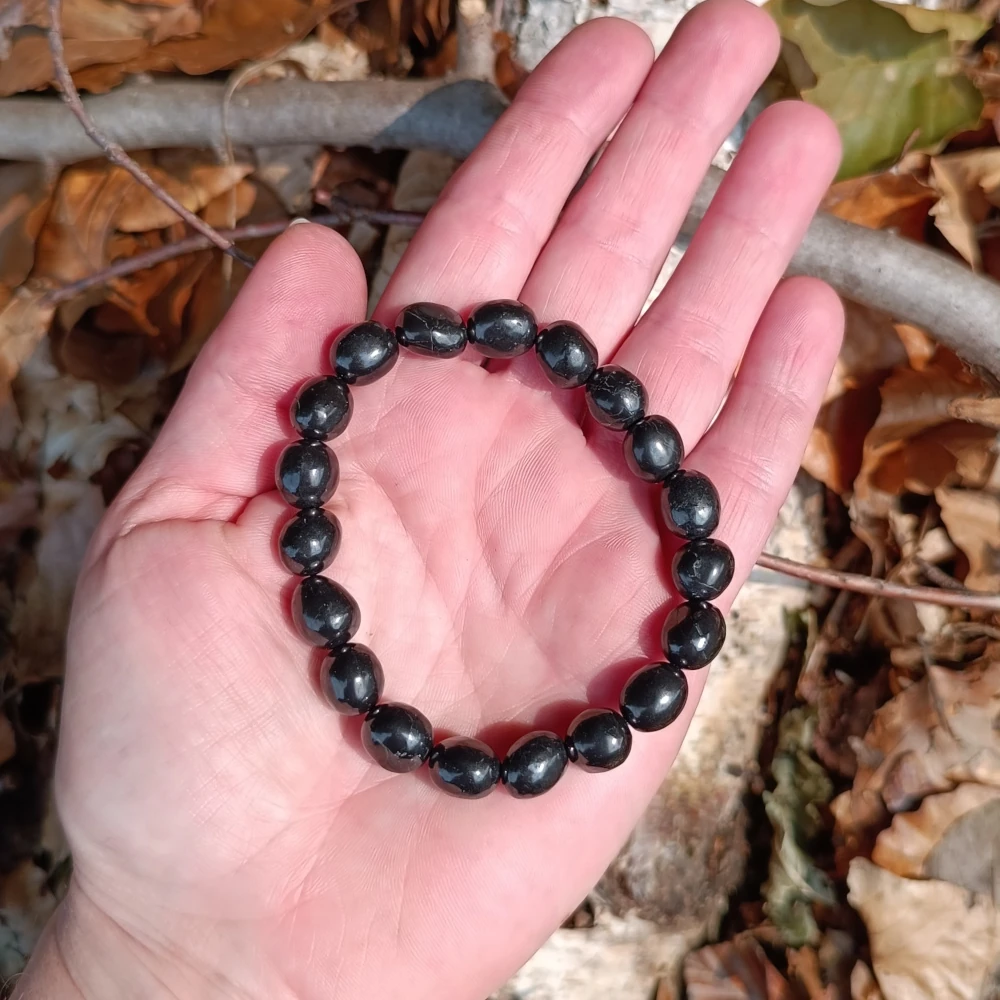Trommelsteinarmband aus Schungit in der Hand