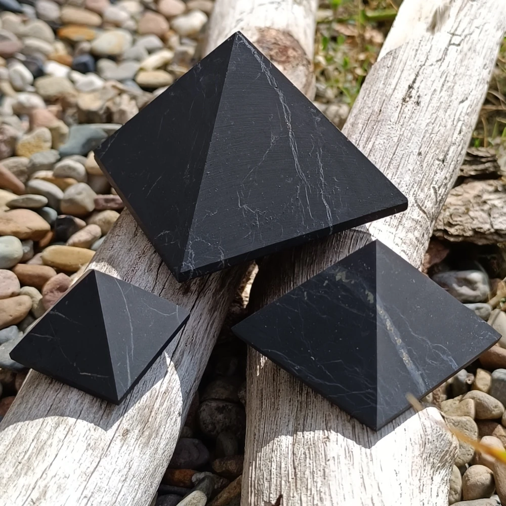 Schungit Pyramiden in verschiedenen Groessen auf Holz
