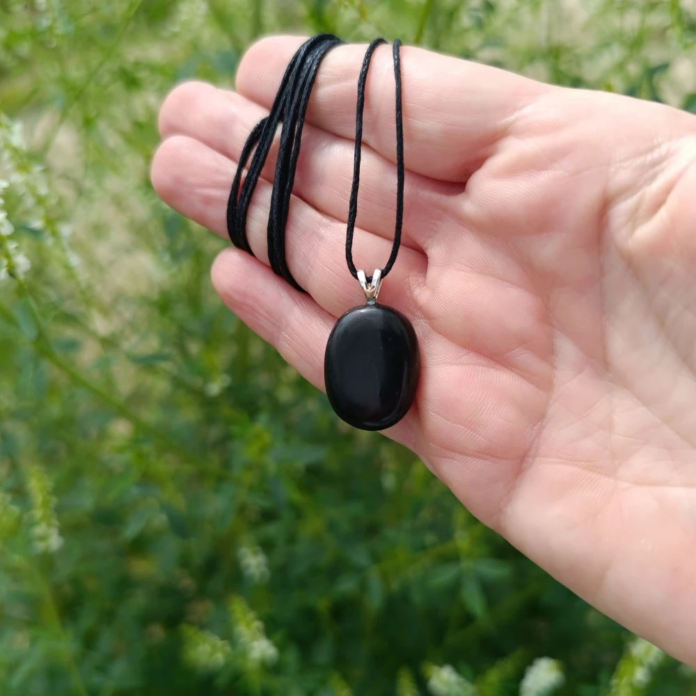 Schmuckanhänger aus Schungit in der Hand