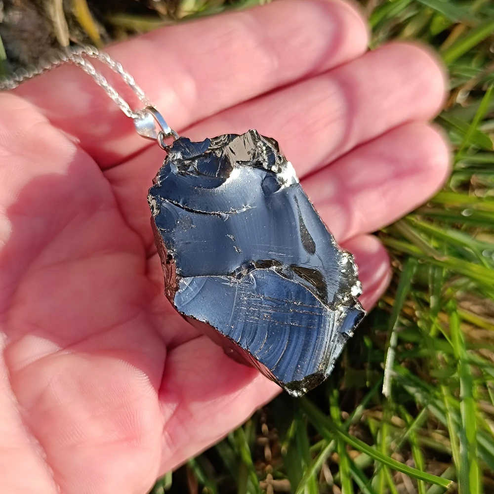 Edelschungit Anhänger auf Baumstamm liegend