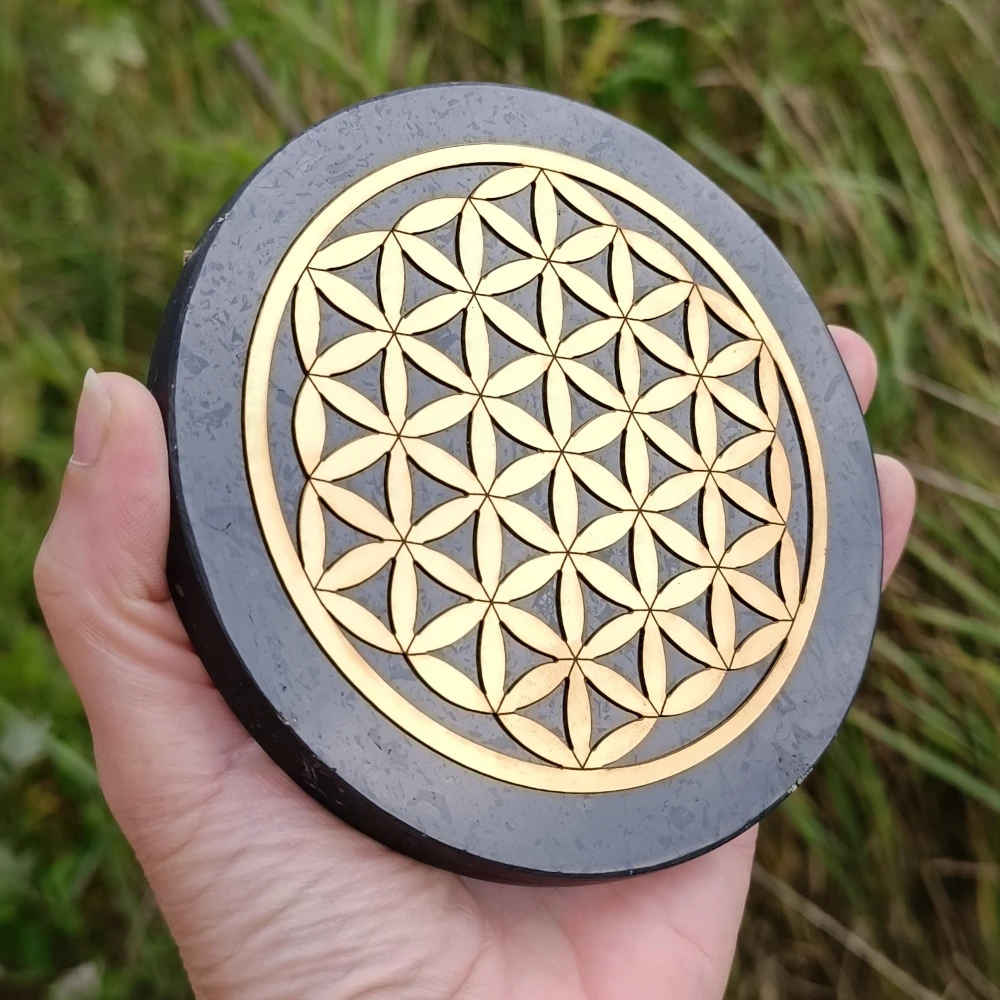 Scheibenfoermige Schungit Platte mit Lebensblume Symbol in Gold