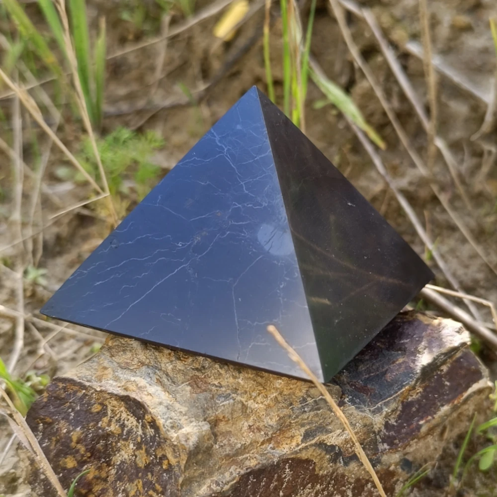 Schungit-Pyramide in einer Hand