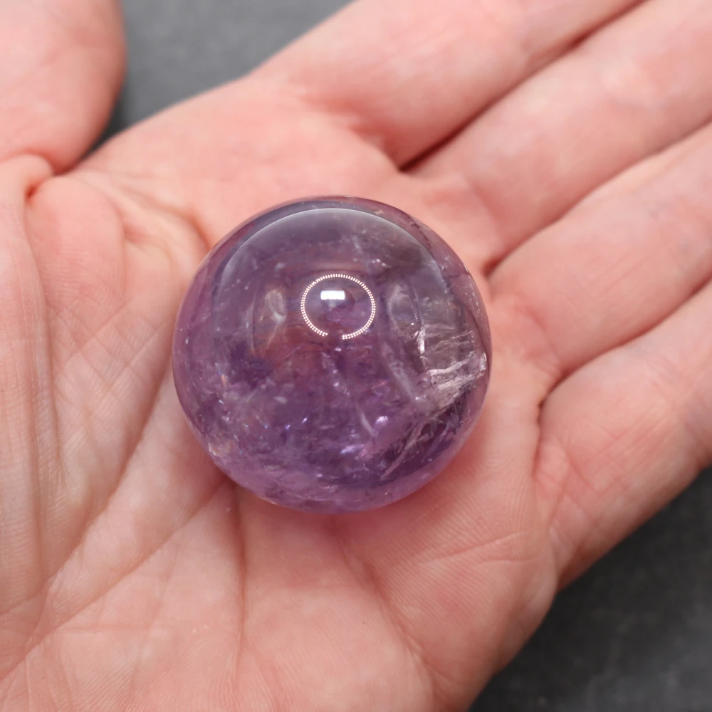 Lila Amethystkugel in einer Hand