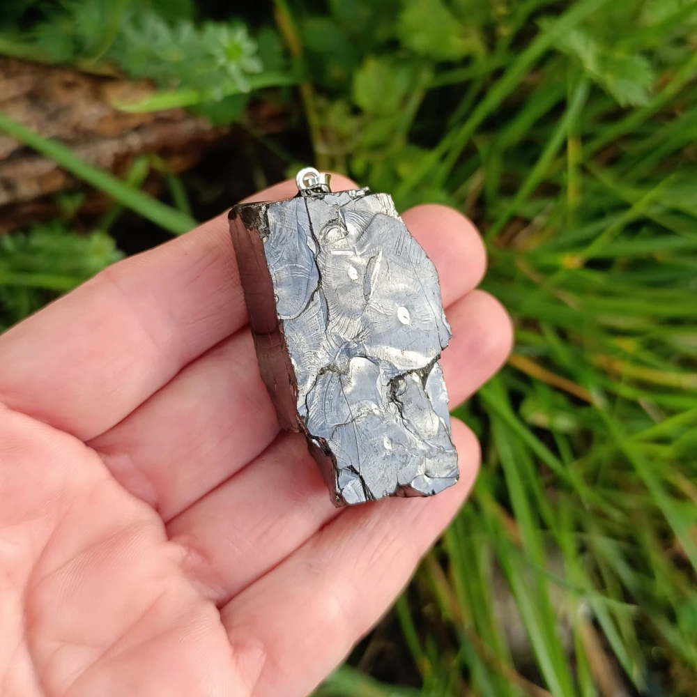 Freeform Anhänger aus Edelschungit in der Hand