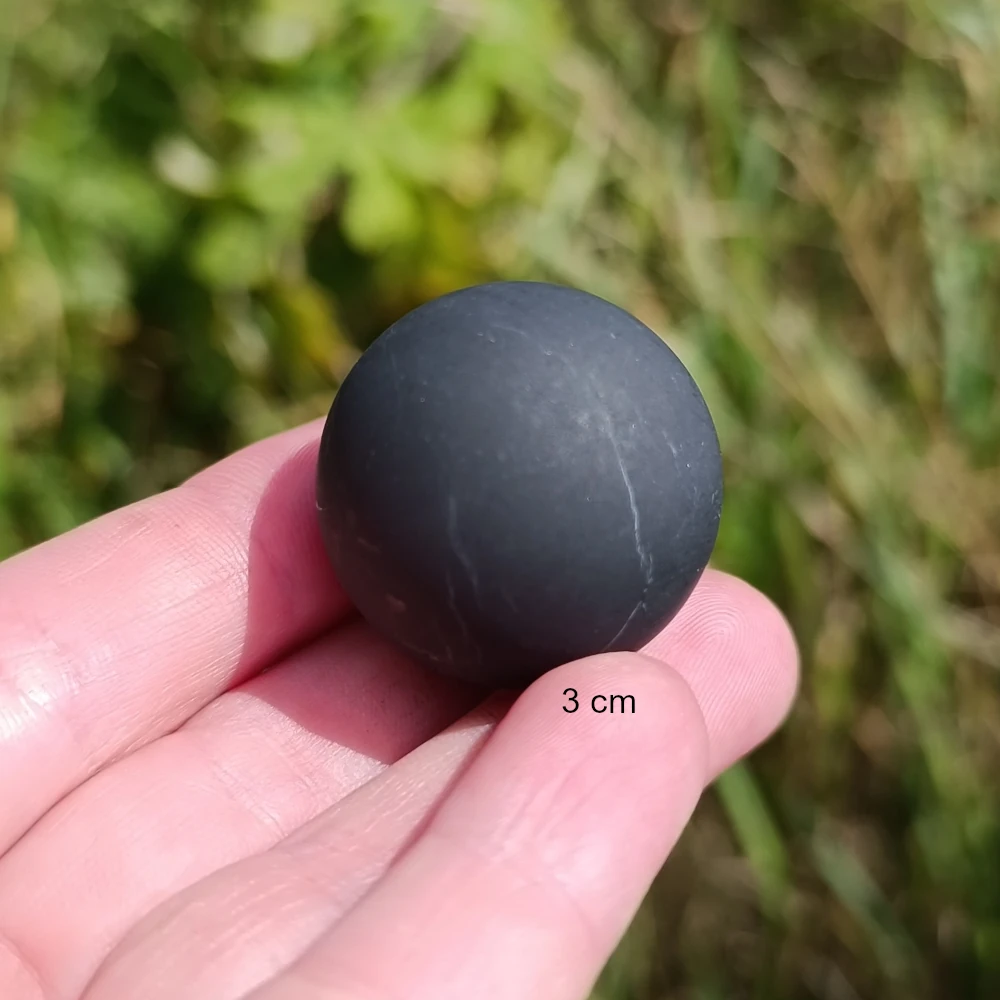 Drei Zentimeter Schungitkugel auf Fingerspitzen