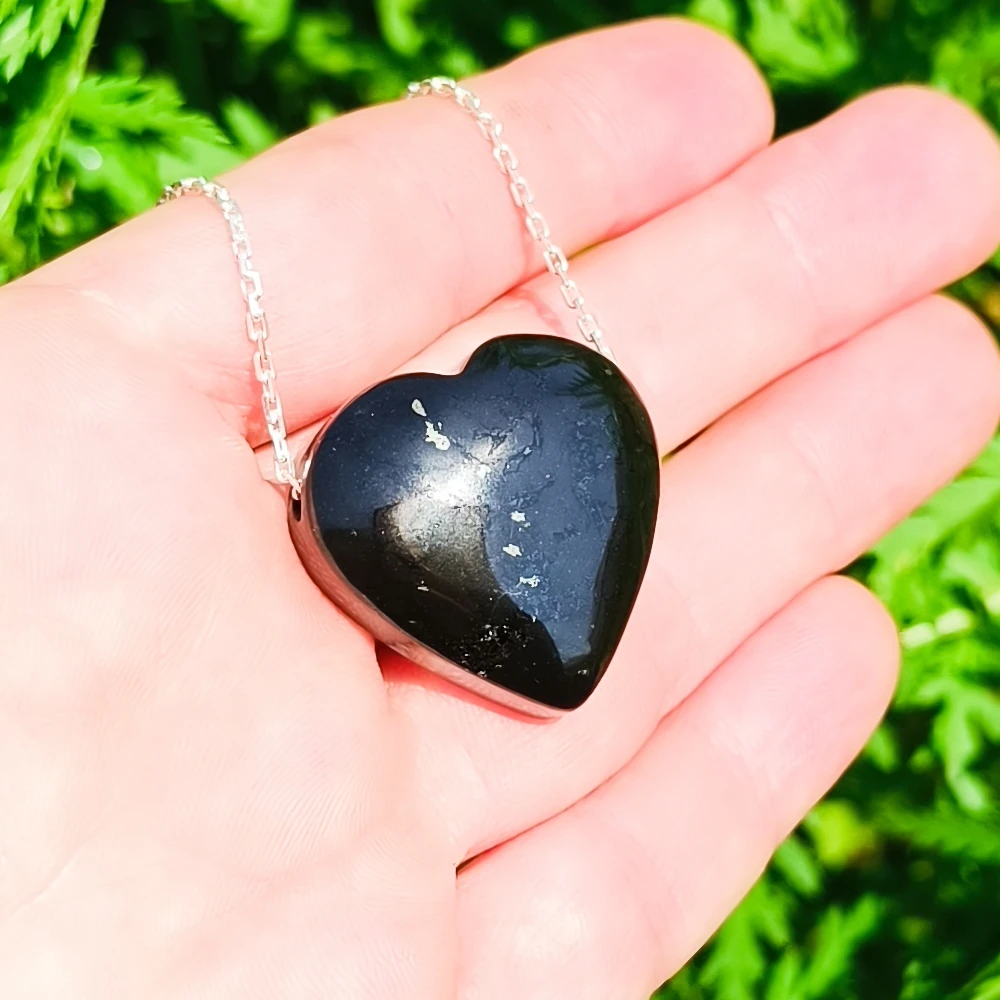 Schwarzes Schungit Herz Kette in der Hand